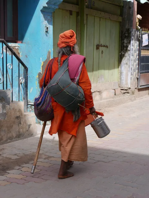 Ein Mann mit Turban und Gepäck in einer Gasse