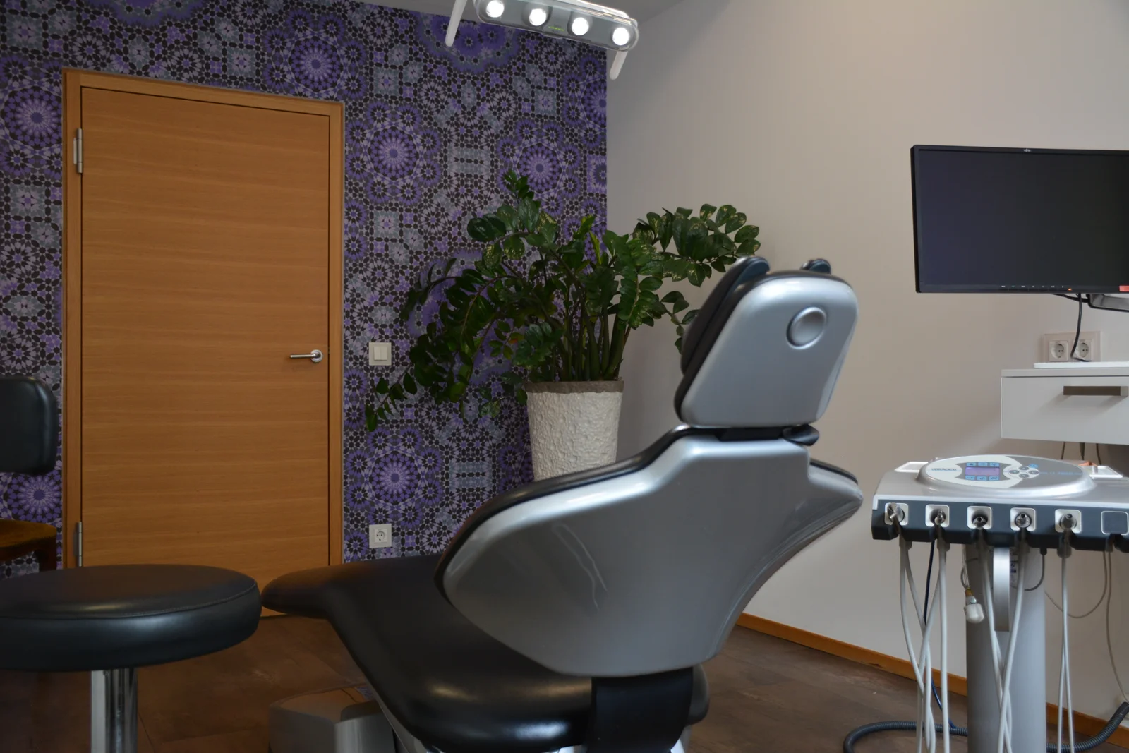 Behandlungszimmer 1 mit violetter Wandgestaltung